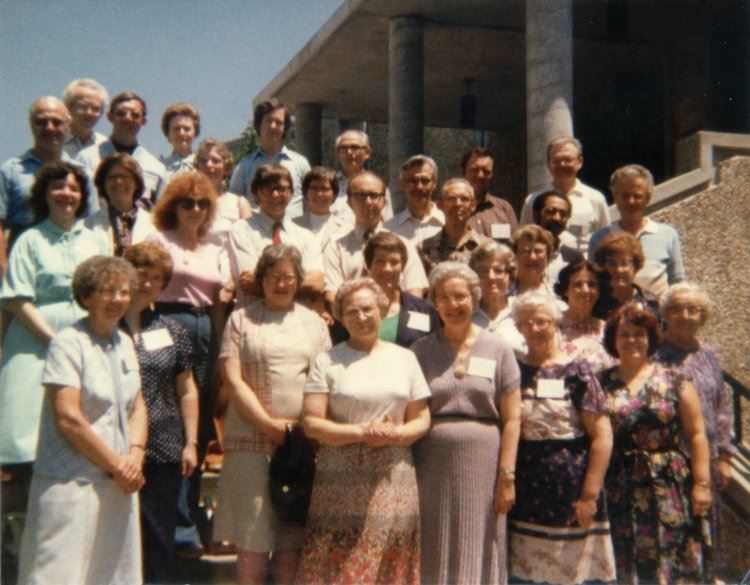 Portrait of a group of people standing staggered on steps representing the first ASDAL conference attendees